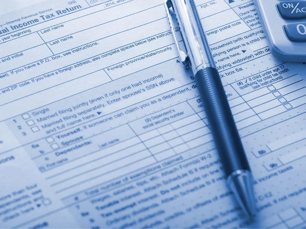 Modulo fiscale dell’IRS con una penna e una calcolatrice
